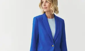 Kobieta w eleganckim żakiecie w intensywnym kolorze kobaltowym, z jasnym t-shirtem pod spodem.