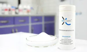 Biała emulsja z benzoesanem benzylu 25% w tubce, obok szalki Petriego z proszkiem. Produkt do pielęgnacji skóry wrażliwej.
