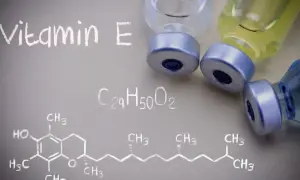 Wzór chemiczny witaminy E i fiolki z płynem. Witamina E jest ważna dla zdrowia.