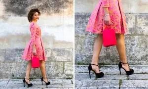 Elegancka kobieta w różowej sukience z złotym wzorem i czarnymi szpilkami. Idealne buty do różowej sukienki na specjalne okazje.