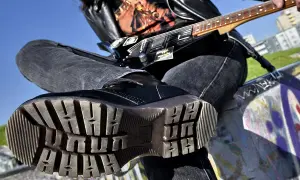 Czarna, błyszcząca glan, dżinsy i gitara elektryczna – kwintesencja stylu grunge.