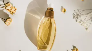 Elegancka butelka perfum, otoczona suszonymi kwiatami. Idealne perfumy odpowiedniki dla Ciebie.
