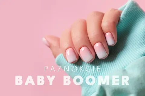 Dłoń z paznokciami w stylu baby boomer, delikatny gradient różu i bieli.