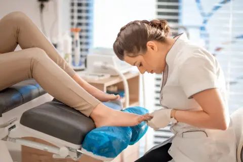 Profesjonalny pedicure co to? Kosmetyczka wykonuje zabieg pielęgnacji stóp, dbając o ich piękny wygląd.