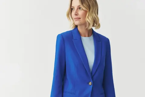 Kobieta w eleganckim żakiecie w intensywnym kolorze kobaltowym, z jasnym t-shirtem pod spodem.