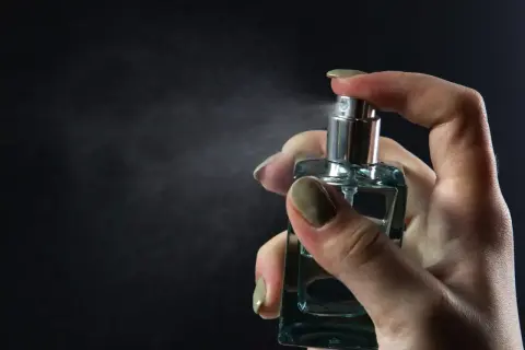 Dłoń rozpyla perfumy. Chcesz wiedzieć, jak sprawdzić, czy perfumy są oryginalne? Zwróć uwagę na detale flakonu i zapach.
