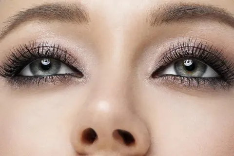Oczy z perfekcyjnym makijażem smokey eye, długimi rzęsami i subtelnym połyskiem na powiekach.