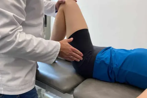 Fizjoterapeuta bada biodra, oceniając zakres ruchu i potencjalne hip dips.