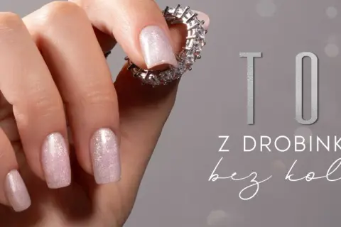 Eleganckie paznokcie z brokatem – idealny pomysł na subtelny manicure. Dłoń ozdobiona pierścionkami z cyrkoniami.