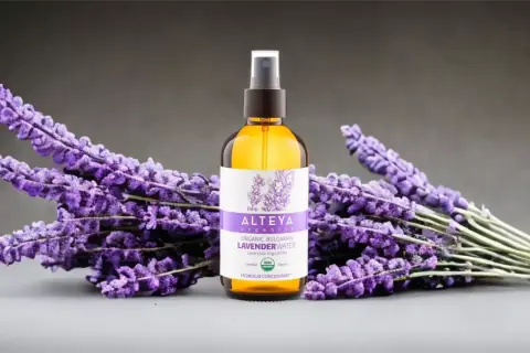 Woda lawendowa Alteya Organics, naturalne wsparcie w walce z trądzikiem, otoczona bukietami świeżej lawendy.