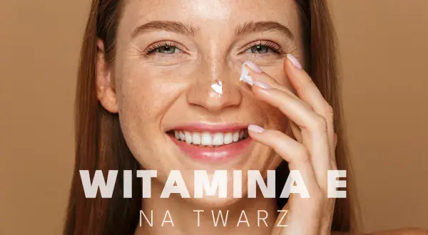 Uśmiechnięta kobieta z piegami aplikuje krem z witaminą E na twarz, dbając o swoją skórę.