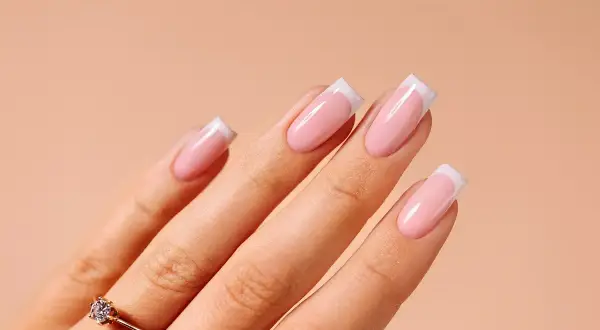 Dłoń z paznokciami w stylu french manicure. Idealny sposób, jak zrobić french, by wyglądać elegancko.