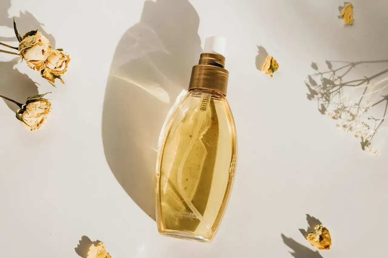 Elegancka butelka perfum, otoczona suszonymi kwiatami. Idealne perfumy odpowiedniki dla Ciebie.