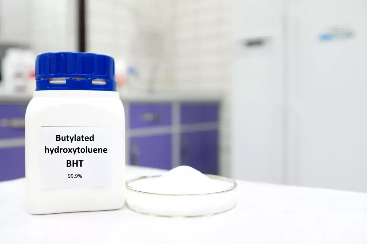 Biały proszek BHT (butylated hydroxytoluene) 99.9% w słoiku i na szalce Petriego w laboratorium.