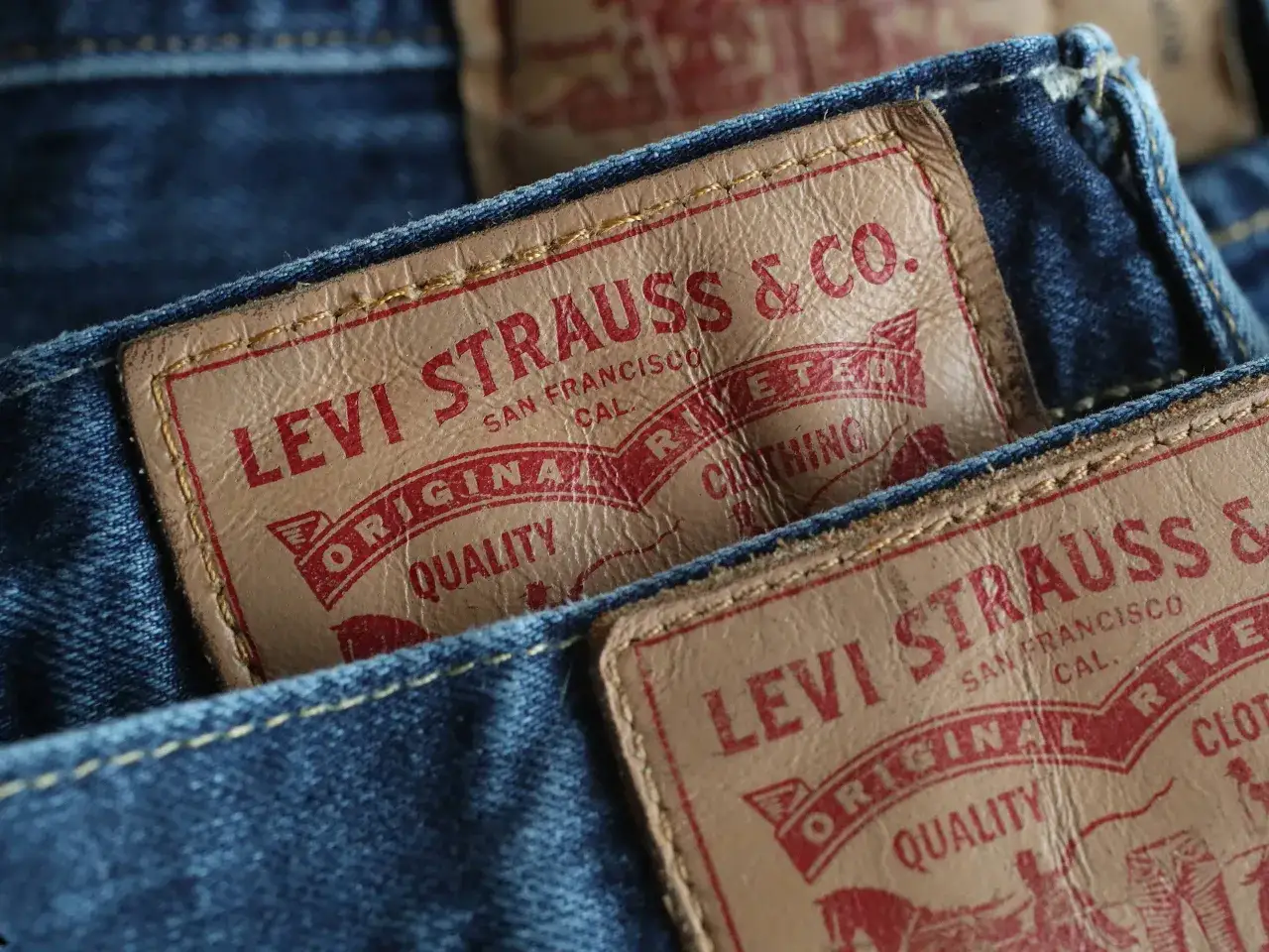 Zbliżenie na skórzane metki z logo Levi Strauss & Co. na klasycznych dżinsach. Oryginalna jakość od Levi Strauss.