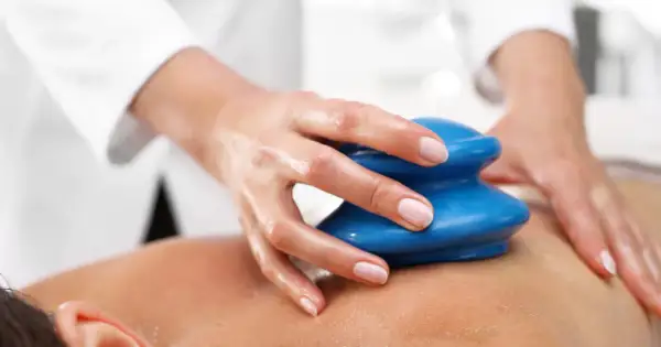 Dłoń terapeuty wykonuje masaż bańką chińską, ukazując jego relaksujące efekty na skórze.