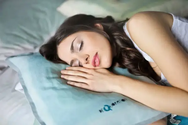 Kobieta śpi na poduszce, dbając o to, jak spać po botoksie, by zachować efekt.