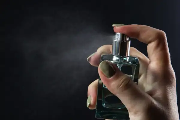 Dłoń rozpyla perfumy. Chcesz wiedzieć, jak sprawdzić, czy perfumy są oryginalne? Zwróć uwagę na detale flakonu i zapach.