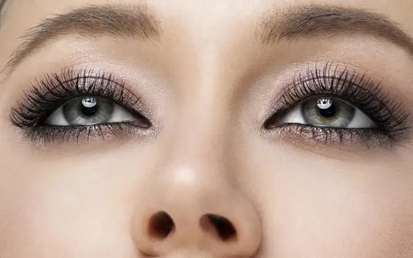 Oczy z perfekcyjnym makijażem smokey eye, długimi rzęsami i subtelnym połyskiem na powiekach.