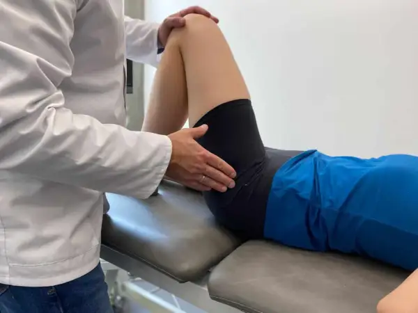 Fizjoterapeuta bada biodra, oceniając zakres ruchu i potencjalne hip dips.