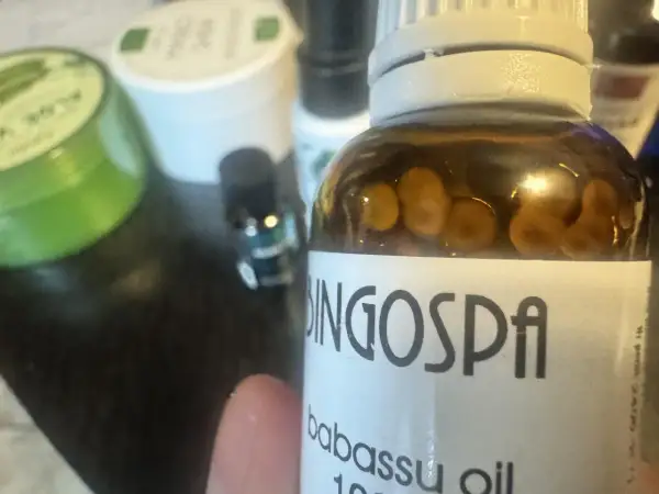 Butelka z olejkiem babassu BingoSpa. W tle zielony słoiczek z aloesem.